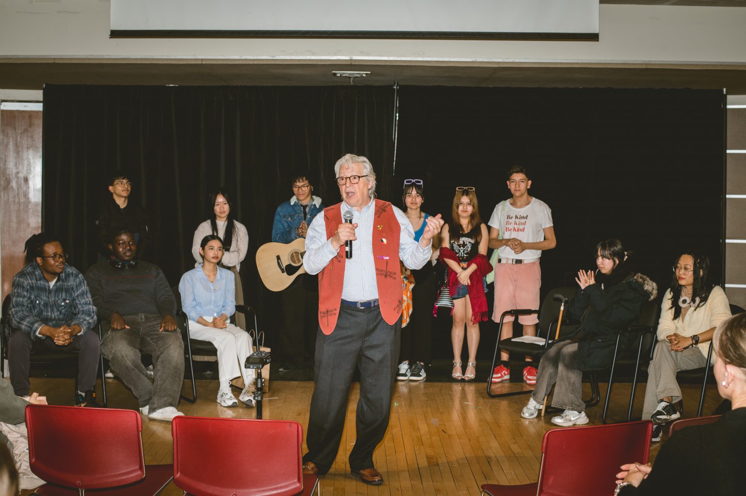 Simon using a microphone to  speak to an audience.
